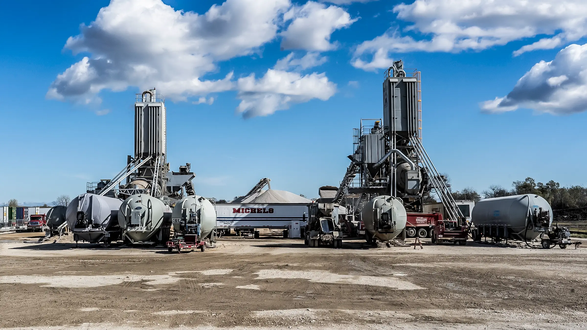 Two batch plants side by side work to create concrete.