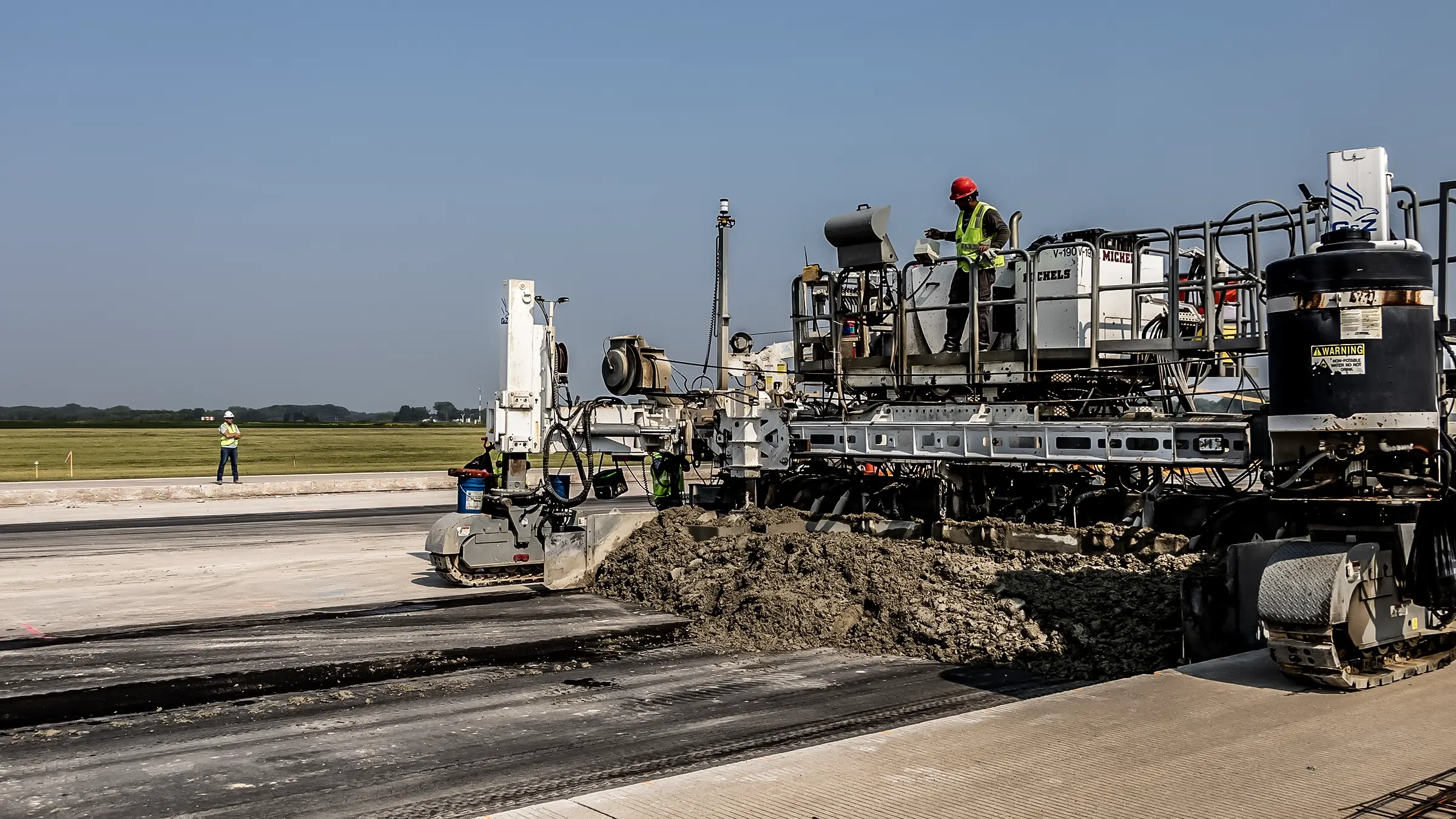 A paving machine operates on an airport runway in Green Bay.