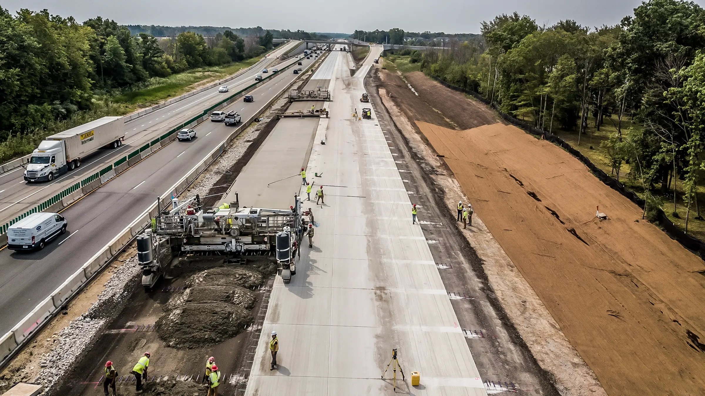 A paving crew works along a busy interstate.