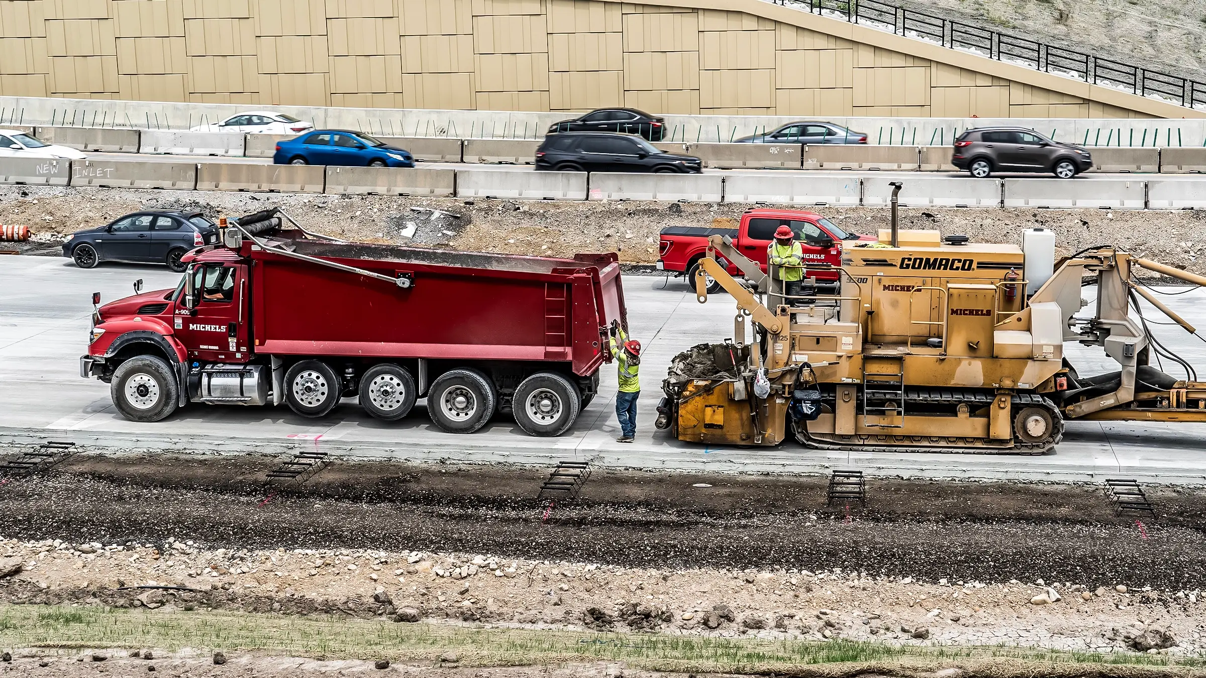 A dump truck and paving machine on a jobsite.