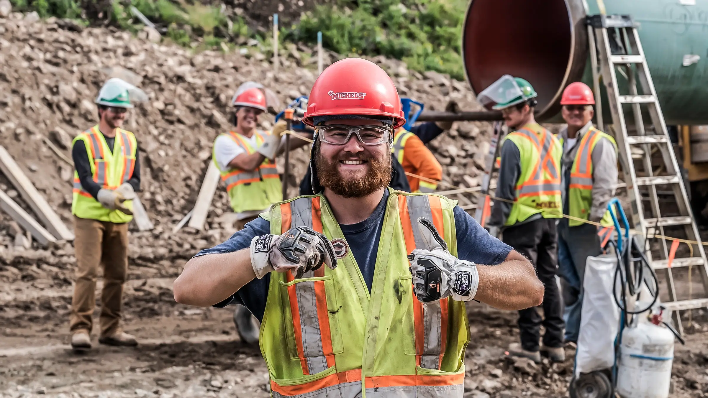 Crew member holding Mi-Promise coin on a pipeline job in Canada.