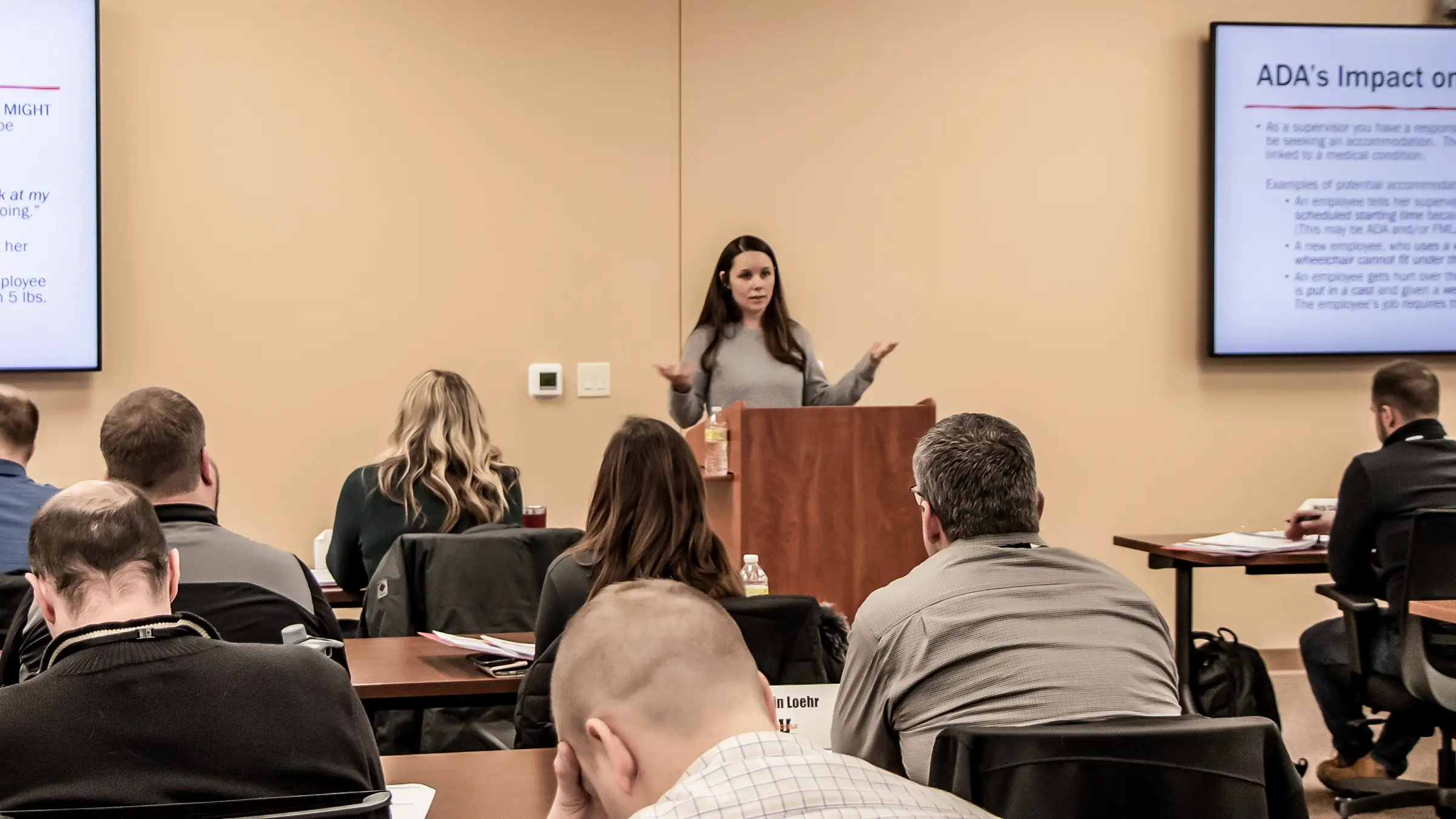 A speaker at a management essentials course stands in front of a crowd.