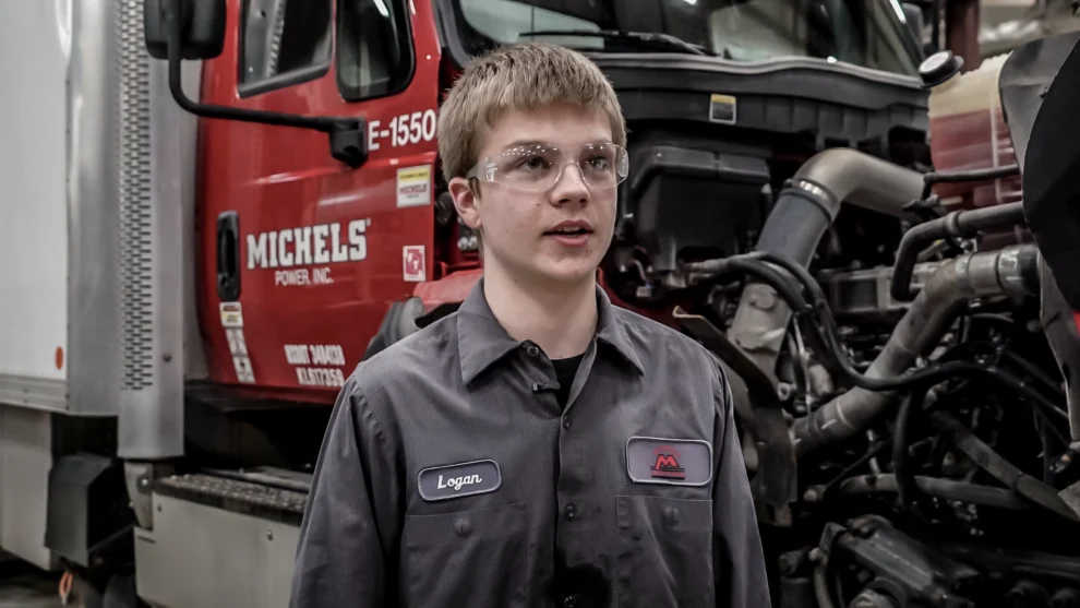A youth apprentice near a diesel truck.
